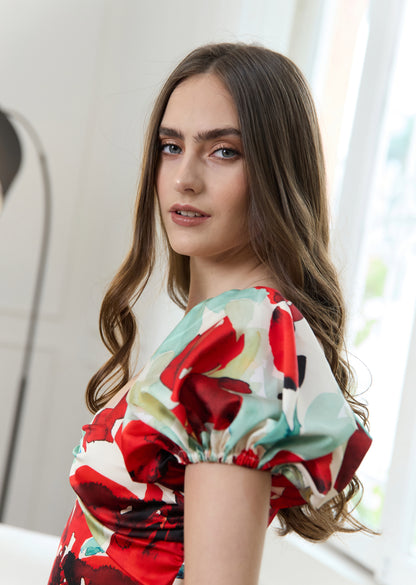 Mujer en sala con vestido de flores rojas