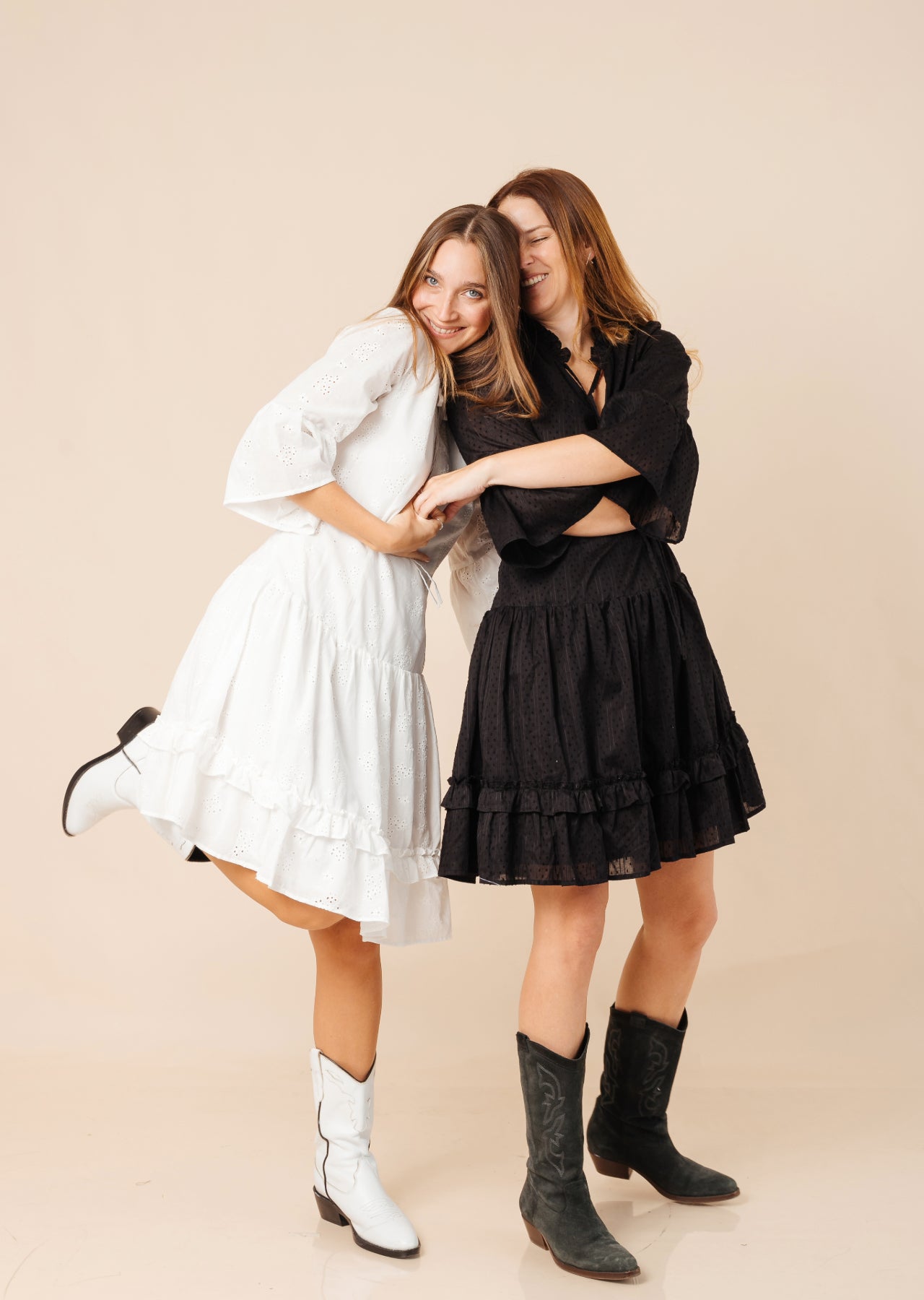 Dos mujeres con vestidos a la rodilla y botas en color blanco y negro.